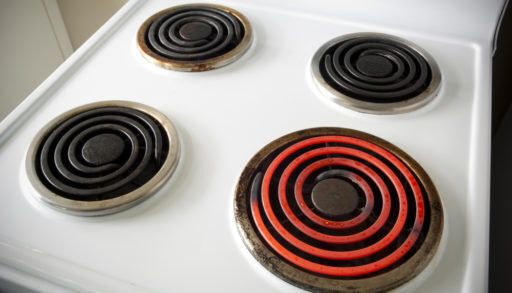 Four electric elements on a stove with one turned on