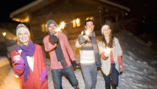 friends with sparklers at a log cabin
