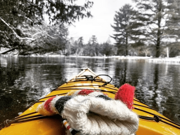 mittens on a kayak on a snowy river