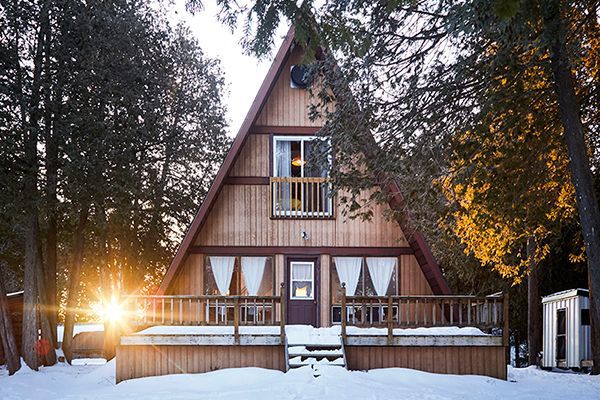 outside shot of A-frame cottage in the snow