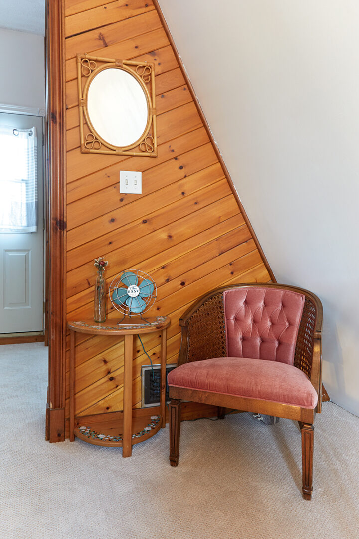 red velvet chair sitting in corner of the a-frame