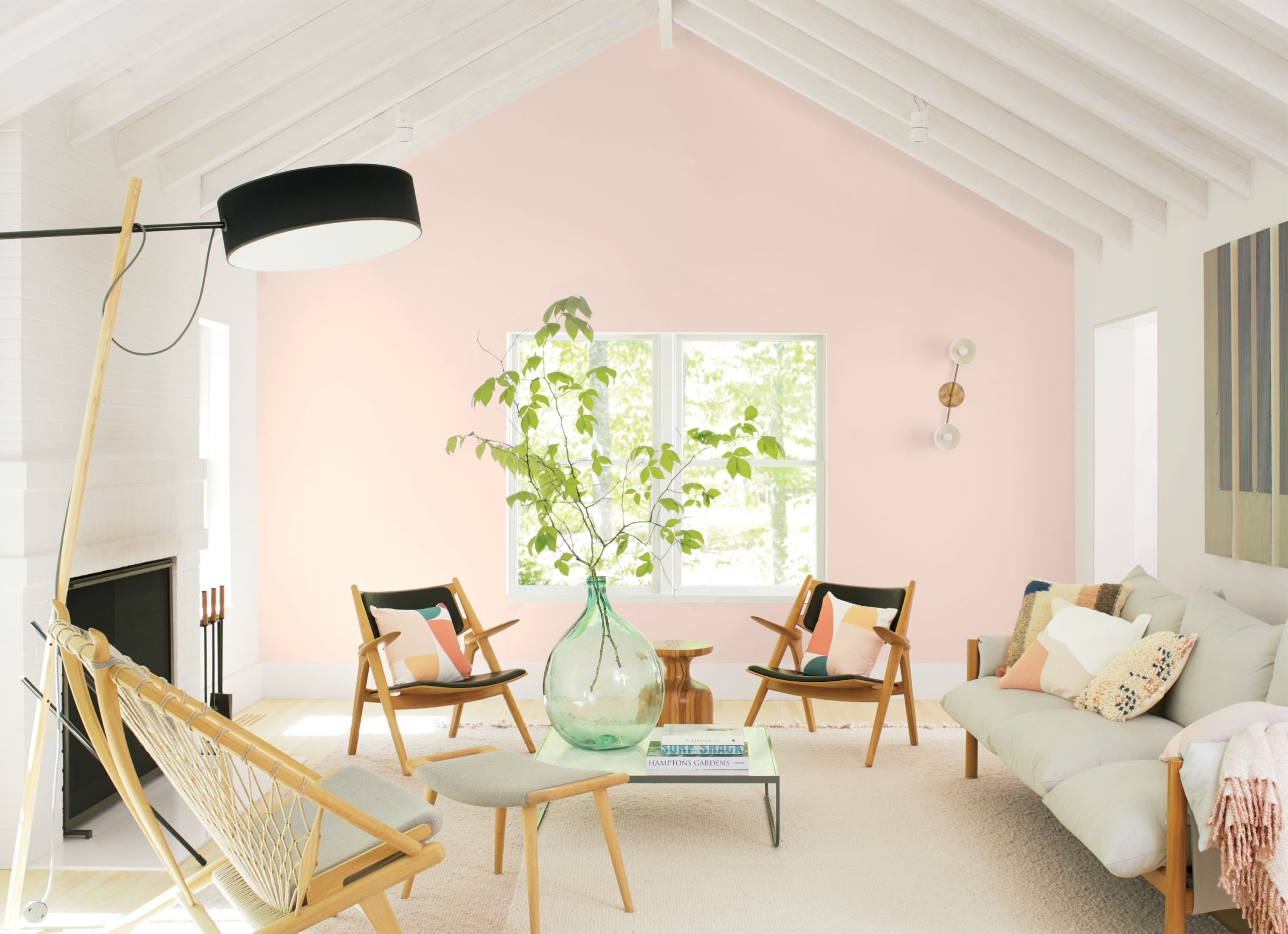 A room with pink walls, a white ceiling and wooden furniture