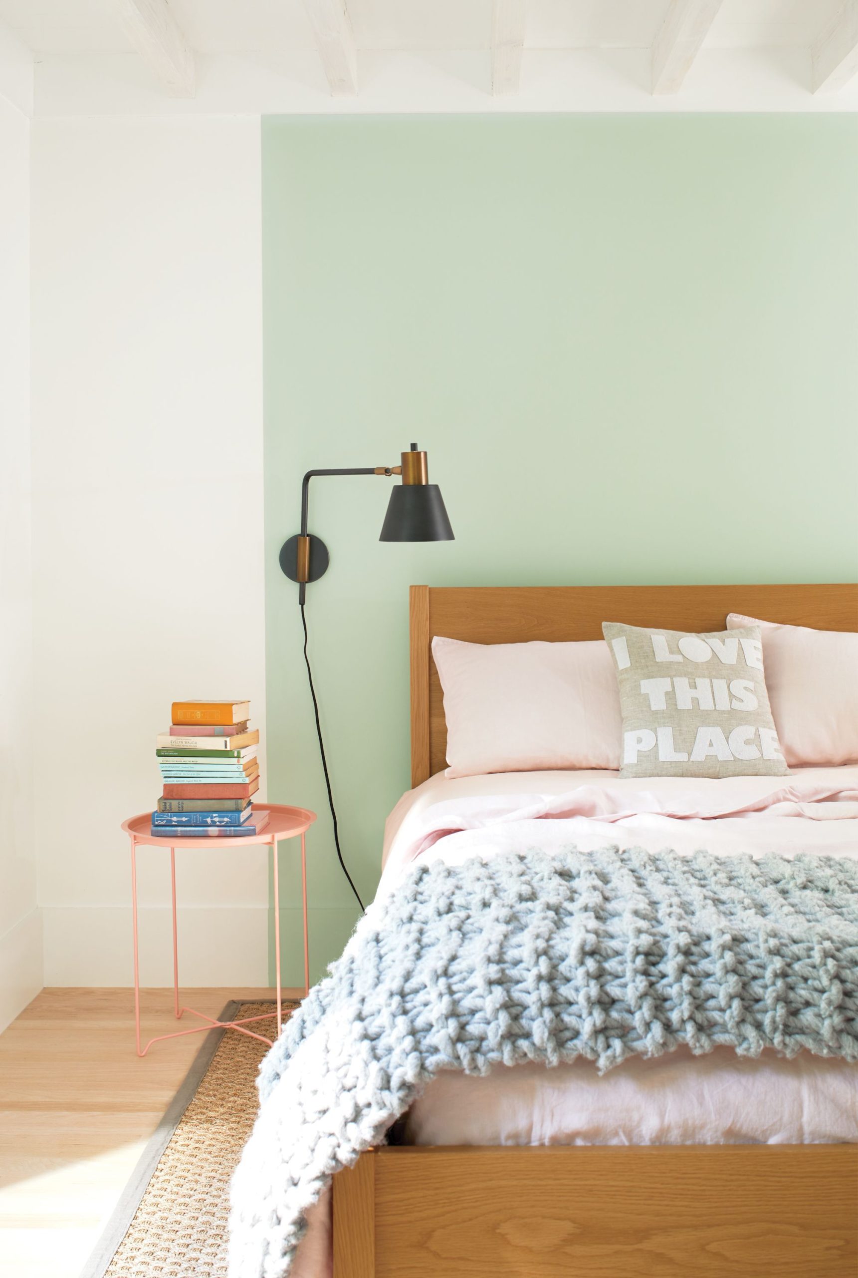 A bed against a green square painted on a white wall