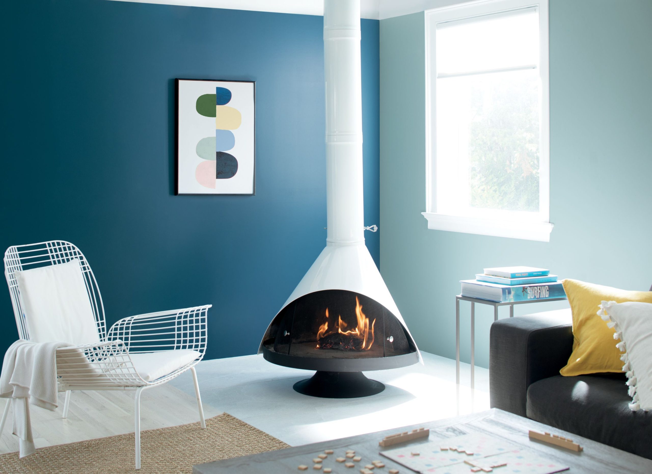 A contemporary white fireplace against a dark blue wall