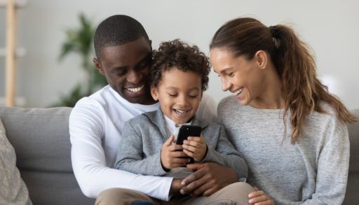 Family looking at phone on couch