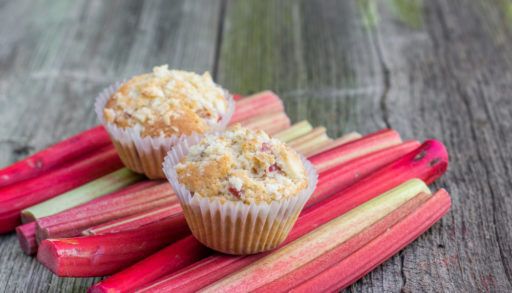 Rhubarb muffins resting on rhubarb stalks