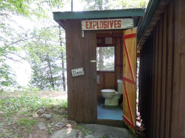 An outhouse with a sign titled "explosives"