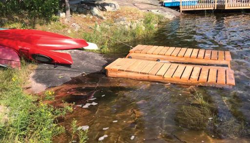 diy project sitting on rocky lake shore, canoe and kayak launch pad