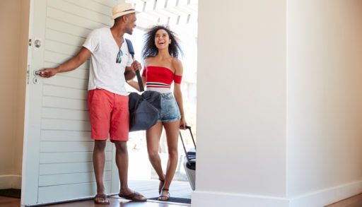 couple enter a summer vacation rental