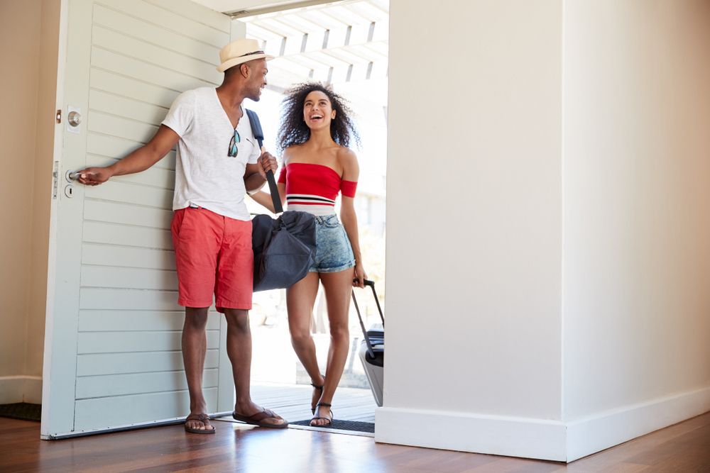 couple enter a summer vacation rental
