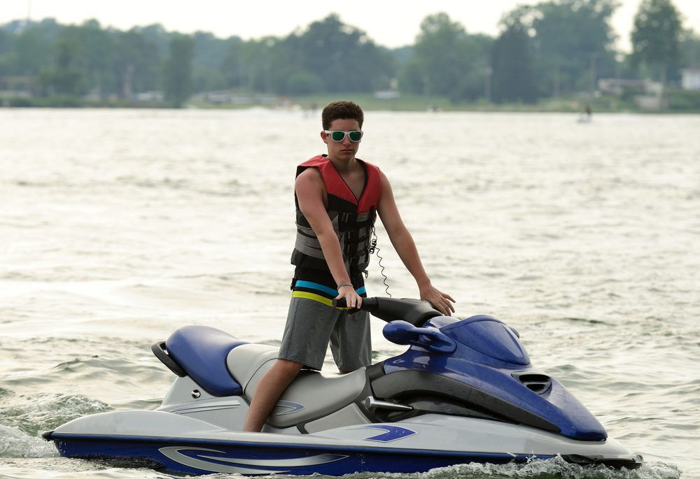 A teen boy on a PWC on the lake