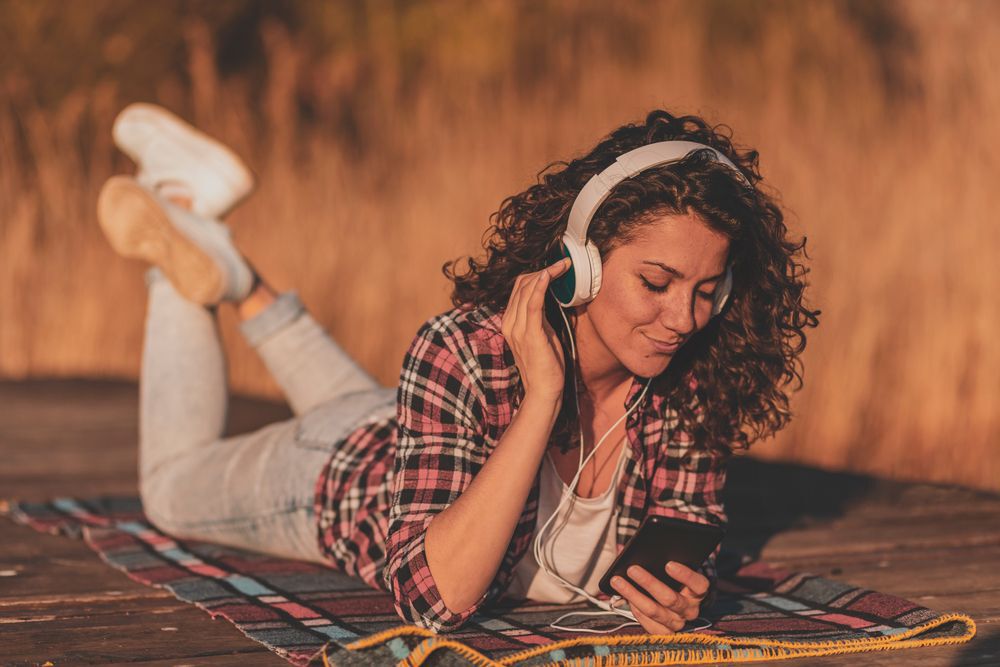 Woman listening to music on dock