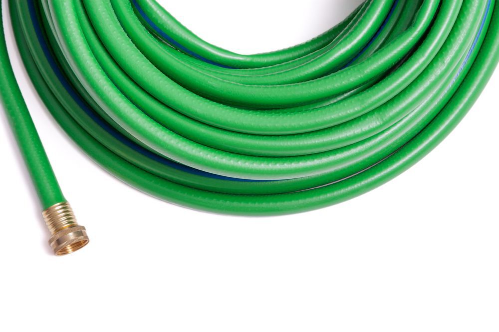 Rolled up garden new green garden hose top frame border isolated on white