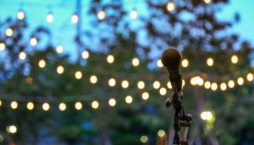 An outdoor shot of a microphone with lights and trees in the background