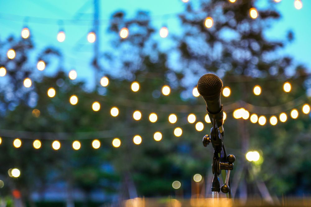 An outdoor shot of a microphone with lights and trees in the background