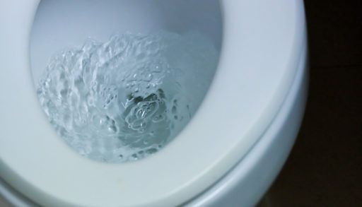 Flushing the toilet at Bathroom or Restroom.Flush white.Water flow flush toilet. concept: sanitary ware ,To cleanse and wash, no plunger