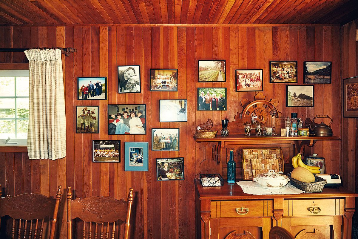 inside of a wooden-clad cottage at bruce beach with lots of family photos on the wall