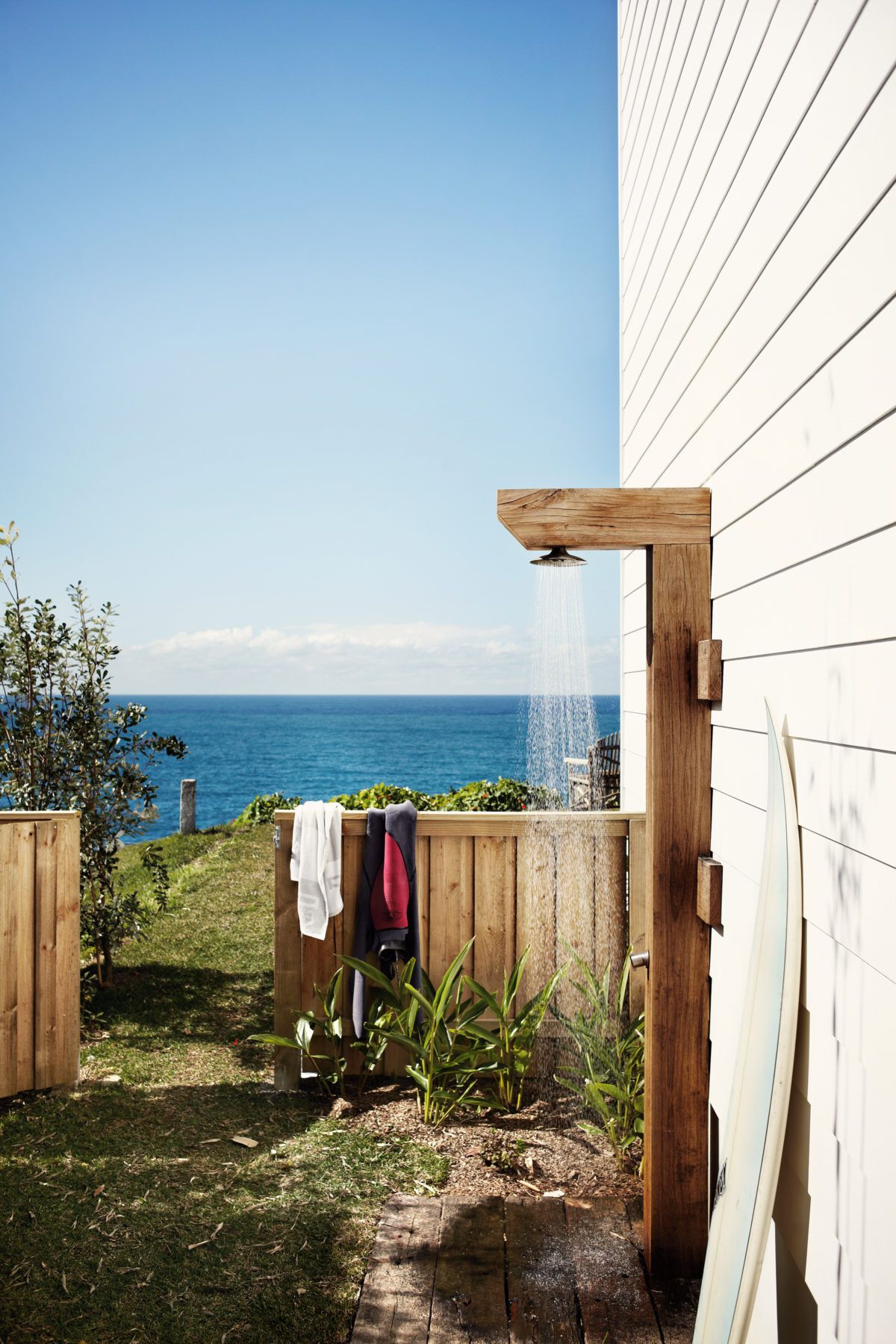 wooden outdoor shower in front of a body of open water