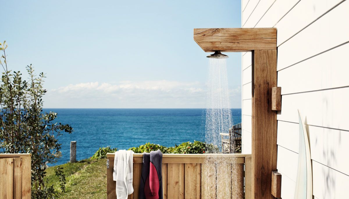 wooden outdoor shower in front of a body of open water