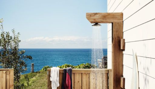 wooden outdoor shower in front of a body of open water