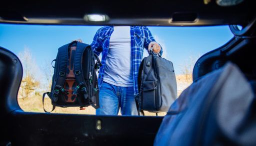 A man loading bags into the trunk of his car