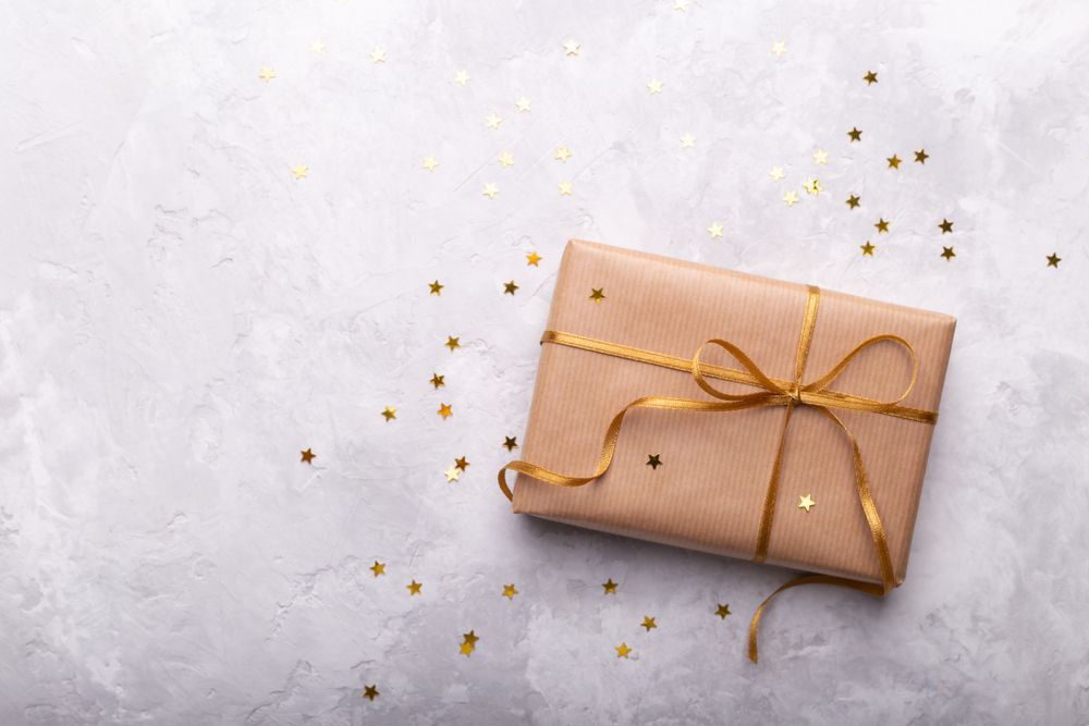 A gift wrapped in brown paper and tied with a yellow ribbon