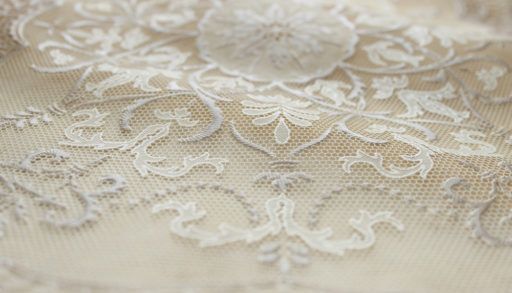 A close-up of an off-white lace tablecloth