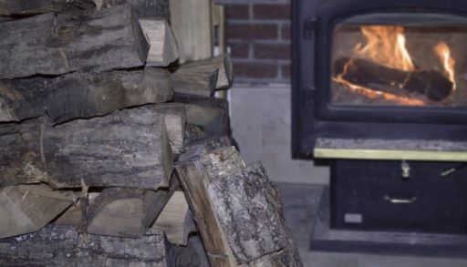 A pile of firewood beside a woodstove
