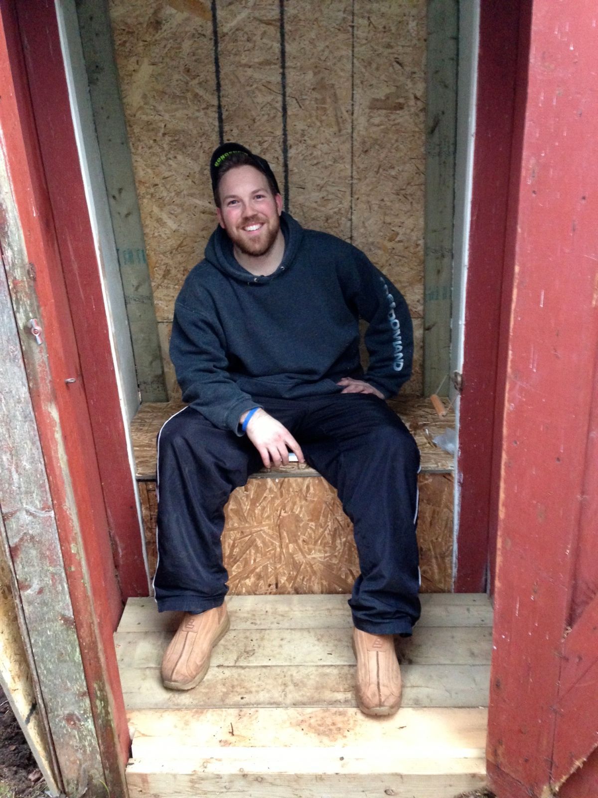 cottage coach adam holman sitting in his rebuilt outhouse