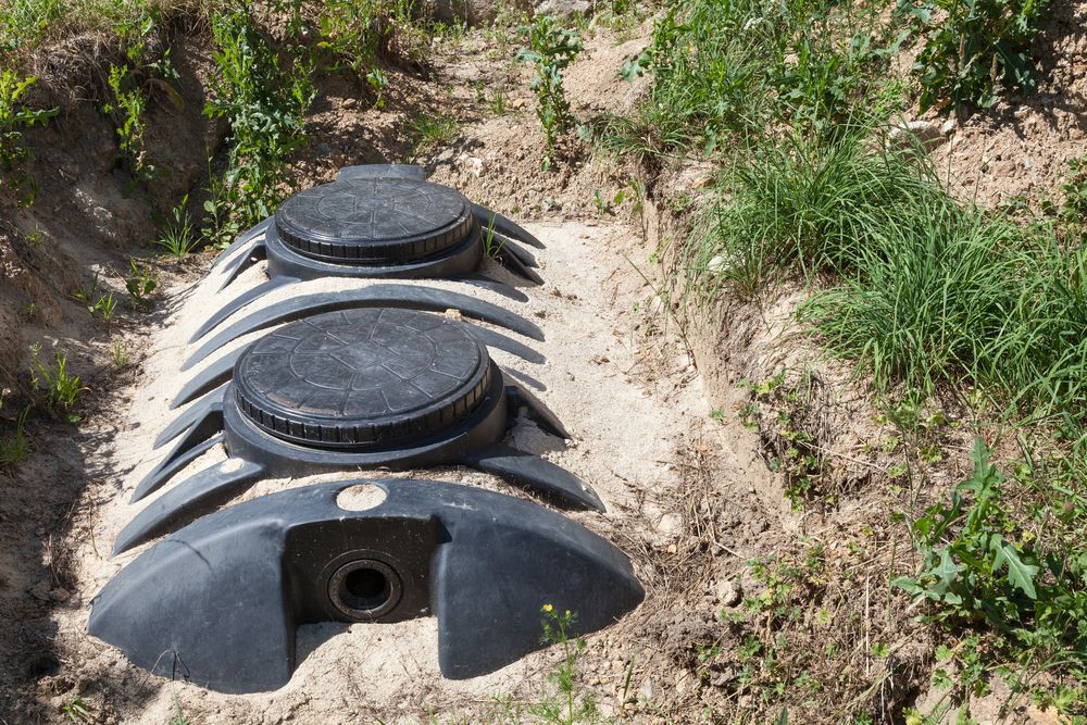 A black septic tank in a sand bed