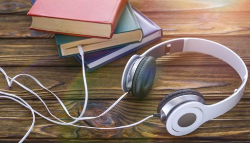 headphones looking like they are plugged into books to represent audiobooks