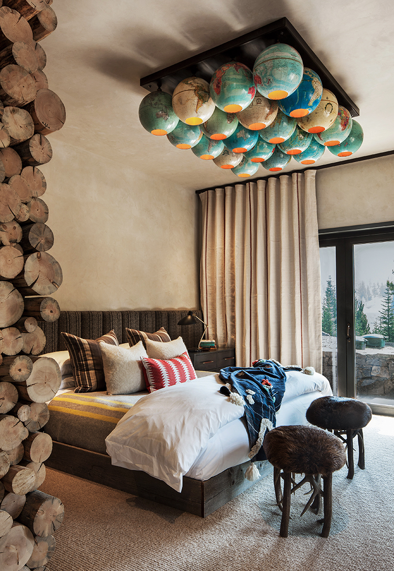 the bunker bedroom with globe light fixture and exposed log wall detail in colin and justin's book escapology
