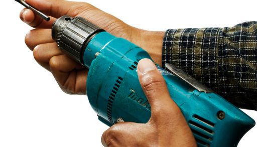 man attaching a drill bit to a blue drill on a white background