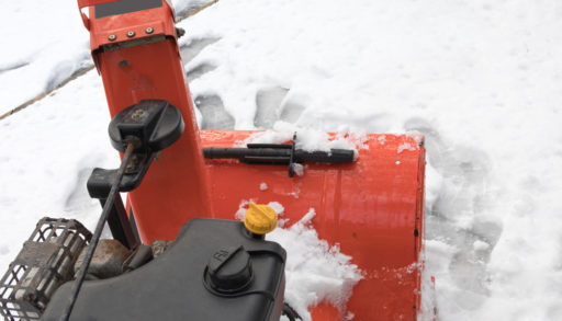 looking forward to the engine and snow chute of an orange snow blower