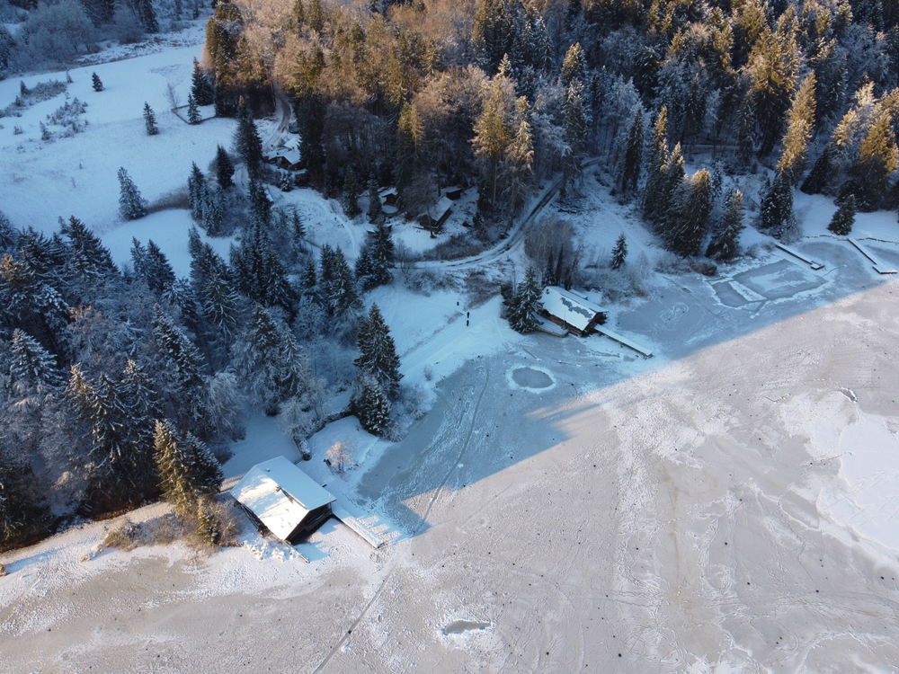 An aerial shot of a frozen lake with docks and boathouses