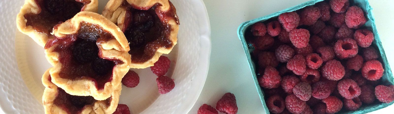 raspberries and tarts on a table
