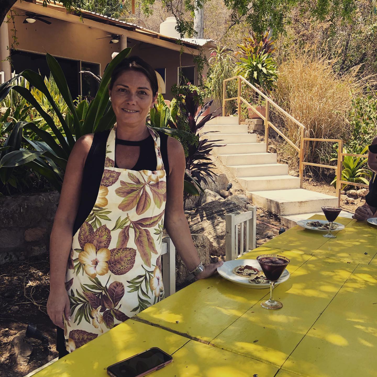 woman standing outdoors with tacos and beverage at Curries Farm Market