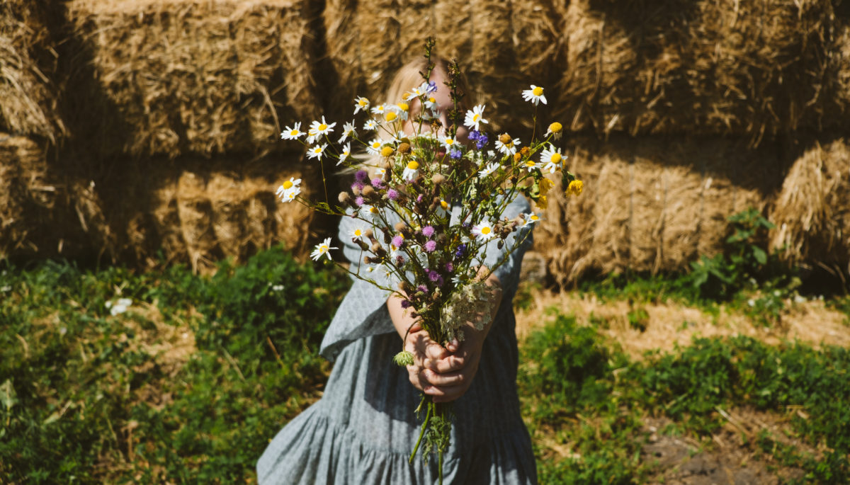 cottagecore girl holds wildflowers in country