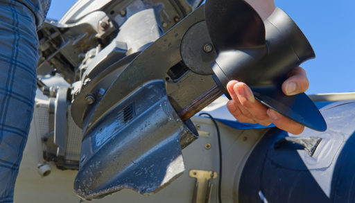 Close up of man changing an outboard engine