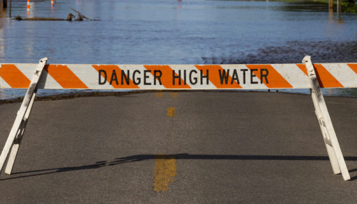 Danger High Water sign in front of flooded road, electrical