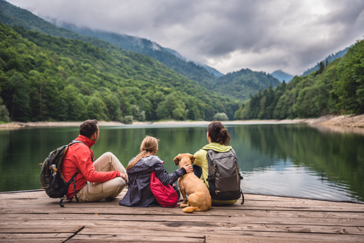 Family with dog sitting on dock