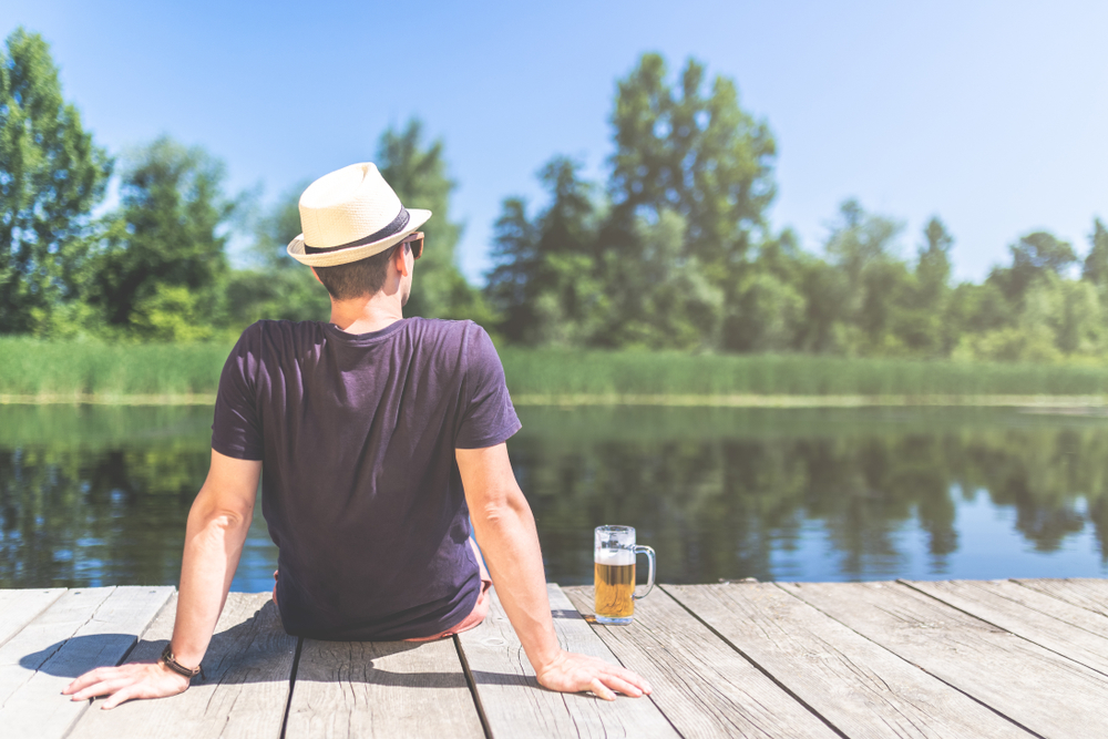 Man sitting on dock with beer
