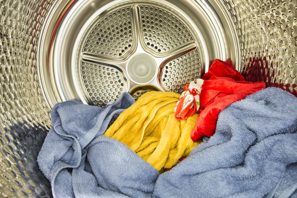 Interior view of tumble dryer with drying clothes.