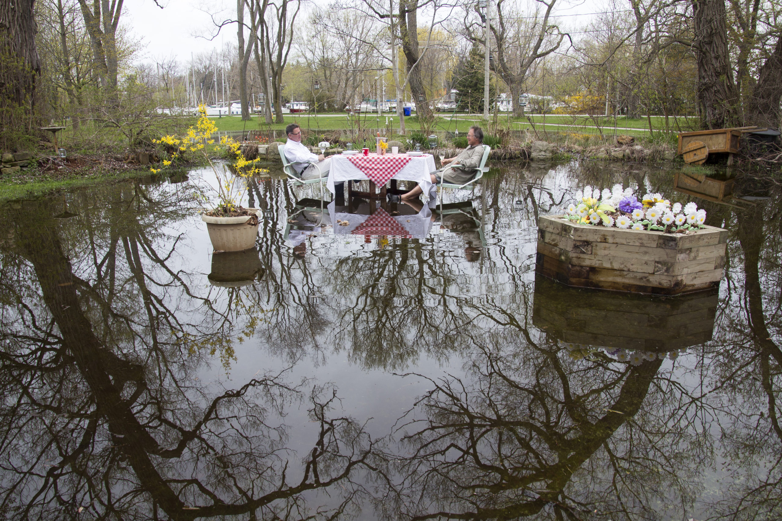 Two men eating lunch in a flooded park
