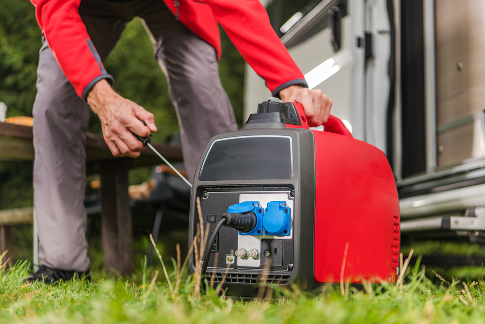 A man firing up a gas powered portable inverter generator.