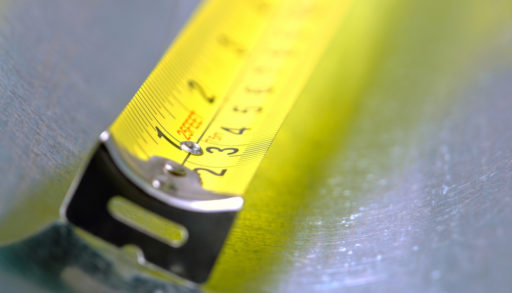 Self-retracting construction tape measure with floating tang in inch and centimetre markings, hand tools