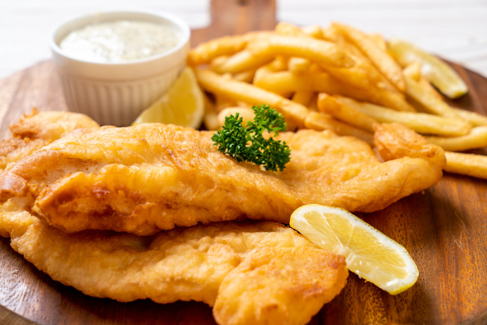 A close-up of fish and chips with a slice of lemon on the side.