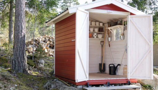 Storage shed filled with garden tools. Shovels, rake, pots, water pitcher and all you need for gardening.