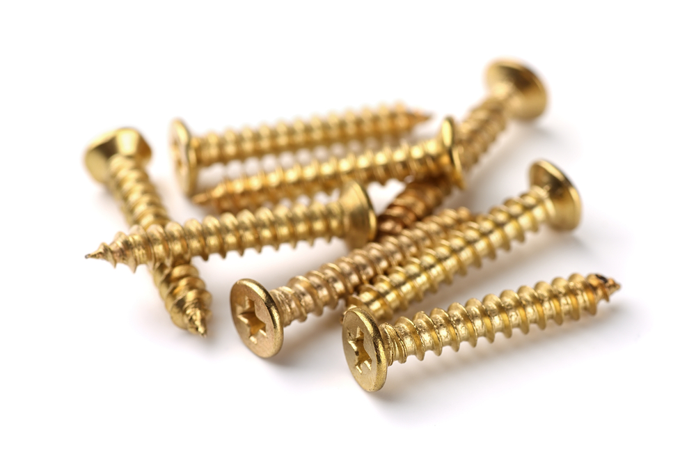 Golden screws on white surface, fastener