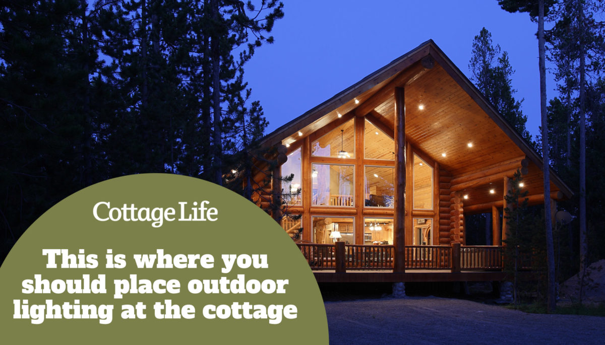 The exterior at dusk of a modern log cabin, in the mountains